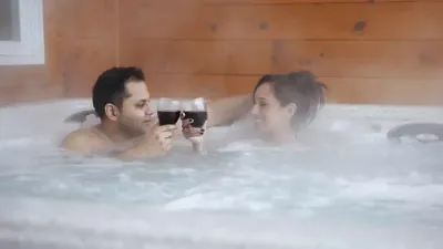 ouple in hot tub with wine glasses